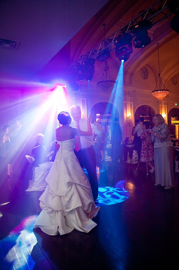 the bride and father of the bride's dance at the reception with blue and purple lighting around them - bride is wearing a white layered ball gown dress - photo by Houston based wedding photographer Adam Nyholt 